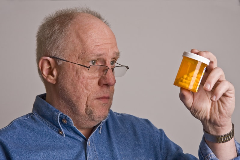 Man looking at pill bottle